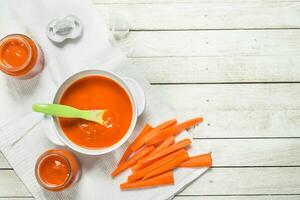 bébé aliments. bébé purée de Frais carottes avec une cuillère. photo