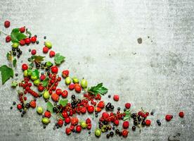 baies avec menthe feuilles sur pierre Contexte. photo