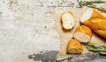 pain ciabatta avec herbes sur papier. sur rustique Contexte. photo