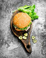 Frais Burger avec des légumes et légumes verts sur un vieux planche. photo