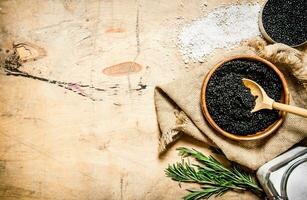 le concept de noir caviar. noir caviar dans tasse avec sel et Romarin. photo