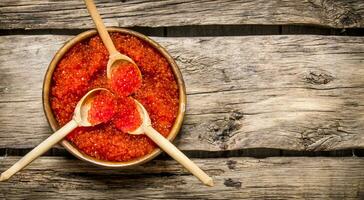 rouge caviar dans en bois tasses avec cuillères. photo