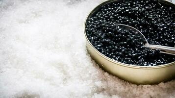 pot avec noir caviar et cuillère de sel. photo