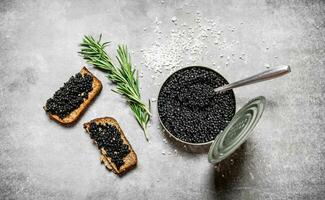 pot avec noir caviar et sandwichs. photo