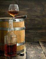 verre de Cognac avec une cigare sur une baril. photo