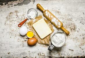 préparation de le pâte. Ingrédients pour le pâte - farine, œufs, beurre avec une roulant broche. photo
