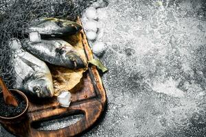 Frais pas préparé dorado poisson sur une Coupe planche. photo