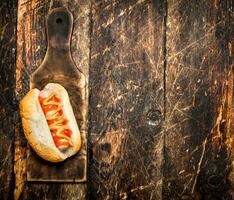 Hot-dog avec moutarde sur le vieux planche. photo