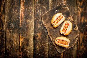 chaud chiens avec moutarde et tomate sauce sur le planche. photo