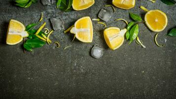 tranches de citron, glace, feuilles sur pierre tableau. photo