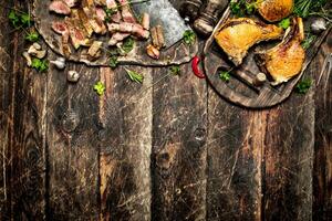 Viande gril. steak de porc grillé avec épices et champignons sur le planche. sur le vieux en bois tableau. photo