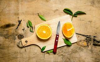 tranché Orange sur une en bois planche avec feuilles. photo