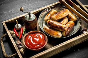 saucisses dans une friture la poêle avec sauce sur une en bois plateau. photo