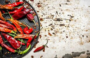 séché le Chili poivre sur le plateau. sur rustique Contexte. photo