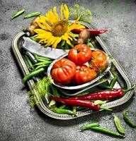 biologique aliments. vert petits pois, tomates et chaud le Chili poivre sur une acier plateau. photo