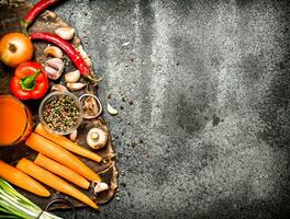 Frais des légumes . Frais des légumes avec épices, herbes et carotte jus. sur rustique Contexte. photo