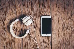 vue de dessus fond bois téléphone et casque. photo