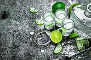 Vodka avec pièces de citron vert et la glace cubes. photo