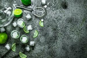Vodka avec pièces de citron vert et la glace cubes. photo