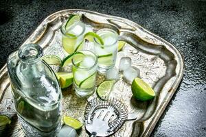 Vodka avec citron vert et la glace sur une acier plateau. photo