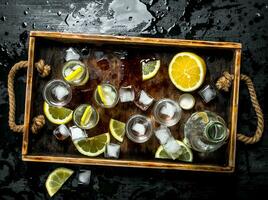 Vodka avec citron et la glace sur une en bois plateau. photo