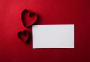 papier coeur rouge et blanc avec carte de note sur fond rouge. photo