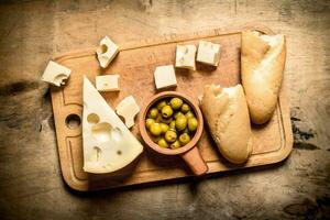 pain ciabatta avec fromage et parfumé olive sur planche. photo