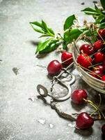 rouge Cerise dans le tasse et métal outil pour cerises. photo