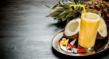 fabrication cocktail avec ananas, noix de coco et Rhum sur le tableau noir . gratuit espace pour texte. photo