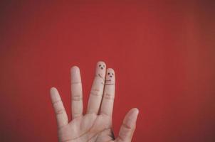doigt avec émotion sur fond rouge. photo