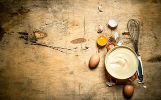 Mayonnaise dans bol avec Ingrédients pour cuisson. photo