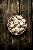 Frais champignons dans panier. sur en bois Contexte. photo