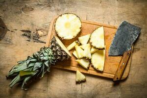 le ananas sur le planche avec un hache. photo