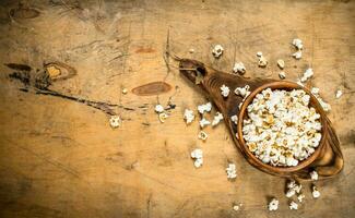 pop corn dans une en bois bol sur le planche. photo