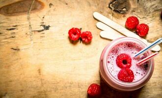 baie smoothie framboise avec en bois des bâtons. photo