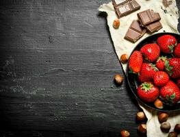 des fraises avec tranches de Chocolat et des noisettes. photo