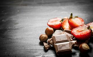 des fraises avec tranches de Chocolat et des noisettes. photo