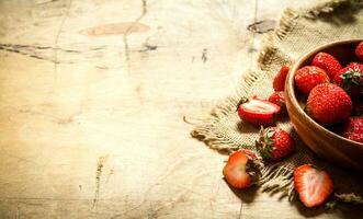 mûr des fraises dans bol sur une sac. photo