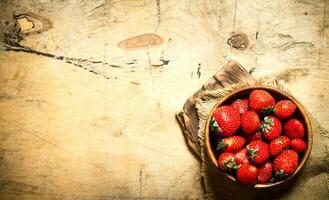 mûr des fraises dans bol sur planche. photo