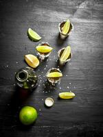 bouteille de Tequila avec coup lunettes, Frais citron vert et sel. photo