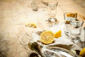 bouteille de Vodka avec coup des lunettes et citron. photo