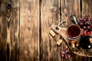 rouge du vin sur en bois planche avec bouchons et une un tire-bouchon. photo