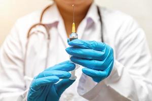 docteur en laboratoire tenant une seringue avec des vaccins liquides