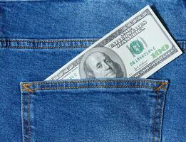 papier américain dollar factures dépasser de le retour poche de bleu jeans photo