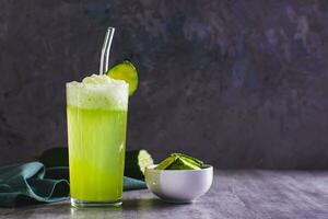 Frais concombre limonade dans une verre sur le table photo