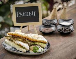 Sandwich panini grillé végétalien aux légumes grillés dans un cadre de table de jardin rustique à l'extérieur en Sicile photo