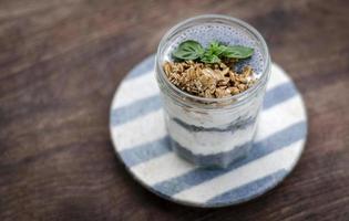yaourt rustique sain fait maison et granola avec des graines de basilic tasse de collation pour le petit-déjeuner photo