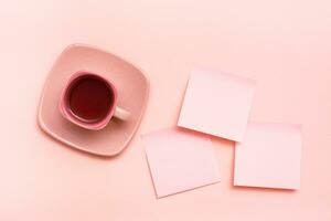 le concept est rose. rose boisson dans une café tasse et feuilles pour l'écriture sur une rose Contexte. Haut vue photo