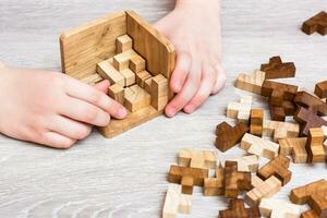 organisation et commande. enfants mains plier le en bois puzzle pièces dans une pliant moule. loisir pour les enfants photo