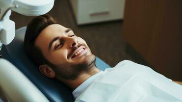 parfait sourire. portrait de content patient dans dentaire chaise. homme avec une blanc sourire photo